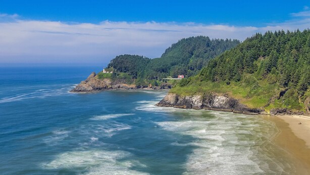 A coastal landscape with a beach, rocky shoreline, and forested hills. - Cozy Dog-friendly Cottage with Great Ocean Views and Fantastic Location (South Beach)