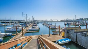 A marina with boats docked at wooden piers, a bridge in the background, and a clear blue sky. - Cozy Dog-friendly Cottage with Great Ocean Views and Fantastic Location (South Beach)