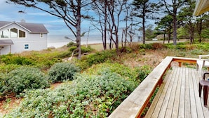 A wooden deck with benches, a white house, and a beach view. - Cozy Dog-friendly Cottage with Great Ocean Views and Fantastic Location (South Beach)