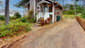 A wooden cabin with a porch, steps, and a door. - Cozy Dog-friendly Cottage with Great Ocean Views and Fantastic Location (South Beach)