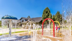 A water play area with a house in the background. - Two-Story Townhouse withFree WiFi, Fireplace, AC, Patio, & Shared Hot Tub, Pools (Eagle Crest)