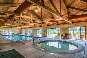 An indoor swimming pool with a wooden ceiling and large windows. - Two-Story Townhouse withFree WiFi, Fireplace, AC, Patio, & Shared Hot Tub, Pools (Eagle Crest)