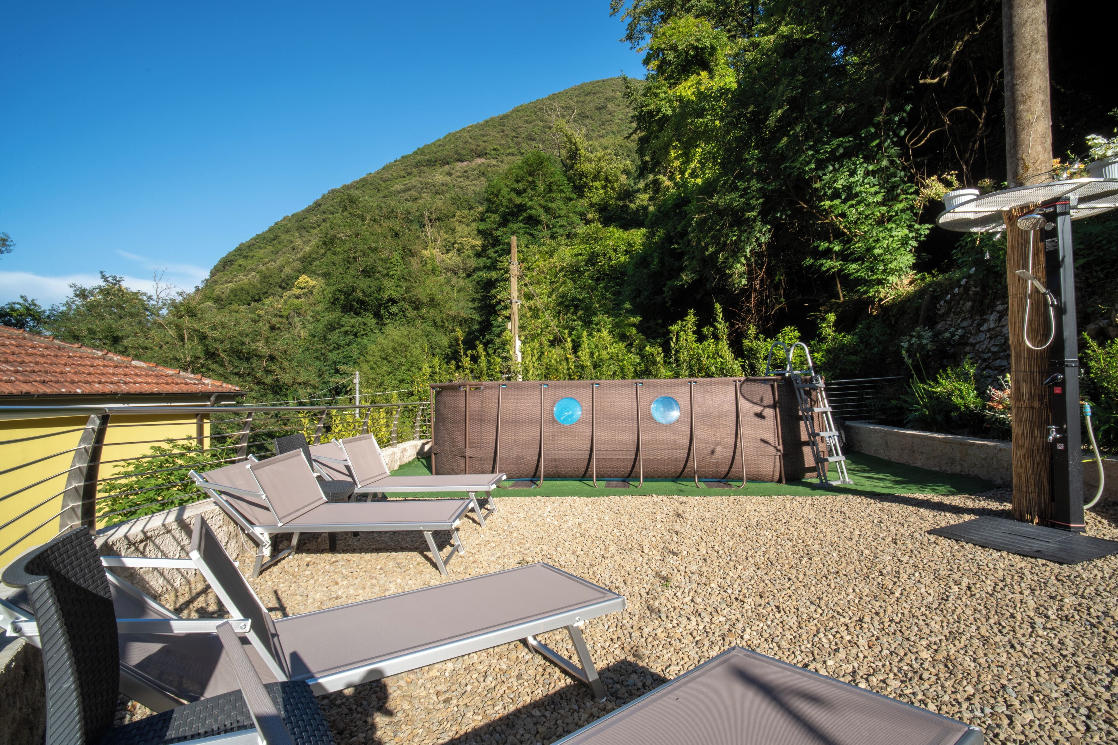 Un espace piscine extérieur doté de chaises longues, d’un jacuzzi et offrant une vue sur les montagnes.