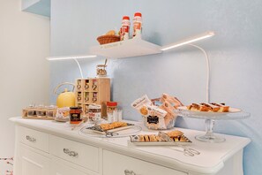 Un plan de travail de cuisine sur lequel on trouve divers aliments, notamment des bocaux, un panier et un présentoir à gâteaux.