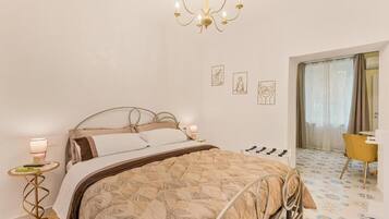 Un dormitorio con cama, lámparas de noche, candelabro, escritorio y silla.