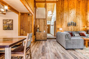 A wooden interior with a dining table, chairs, a sofa, and a lamp. - Dog-Friendly Home with Private Hot Tub & Patio - SHARC Passes to Pools & Tennis (Sunriver)