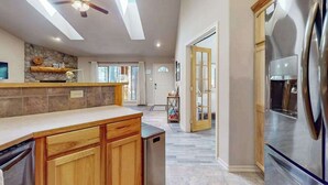 Una cocina moderna con refrigerador empotrado, gabinetes de madera y un ventilador de techo.