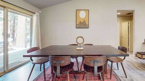 Un comedor con una mesa grande, seis sillas y un tapete.