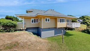 Une maison à deux étages avec un balcon, un garage et une pelouse bien entretenue.