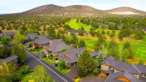 A residential area with houses, a street, and a hilly landscape in the background. - Golf course-front home with deck, hot tub, fireplace, W&D, & community pool (Eagle Crest)