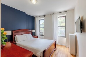 A hotel room with a bed, bedside table, lamp, and a TV mounted on the wall. - 3A 2-bedroom apartment in lovely New York near Central Park (New York)