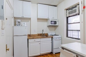 A compact kitchen with white cabinets, a microwave, a stove, and a coffee maker. - 3A 2-bedroom apartment in lovely New York near Central Park (New York)