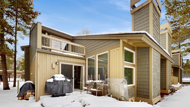 A modern house with a large deck, a covered patio, and a garage. - Open & modern condo with pool, hot tub, fireplace & W&D (Sunriver)