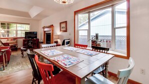 A dining area with a wooden table, chairs, and a large window with a view. - Dog-Friendly, Coastal Escape with Private Hot Tub, WiFi, & Deck - Blocks to Park (Seaside)