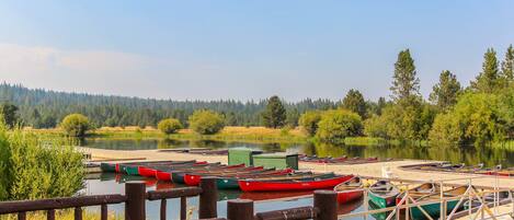 A lakeside dock with canoes and a wooden walkway.