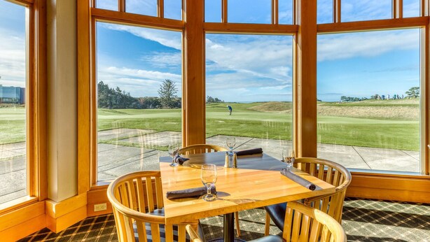 A corner room with large windows, a wooden table, and chairs. - Single-level, dog-friendly home w/ private fenced-in yard & easy beach access (Bandon)