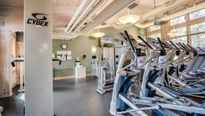 A gym with exercise equipment, a clock, and a bulletin board. - Unique & secluded forest home with pool, hot tubs, tennis, sauna, & basketball (Black Butte Ranch)
