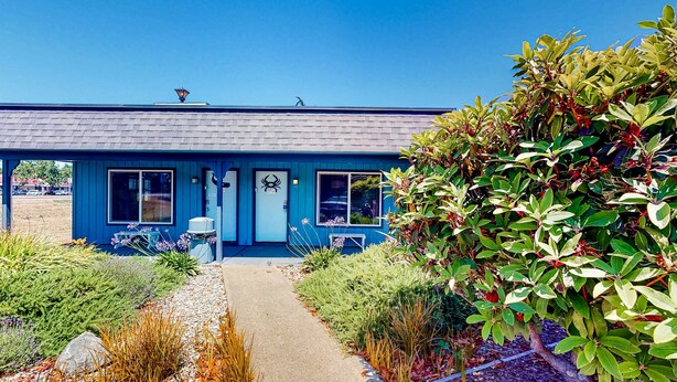 A blue building with a front door, windows, and a small porch area. - Retro getaway near beach with fast WiFI - walk to downtown shops & eateries (Bandon)