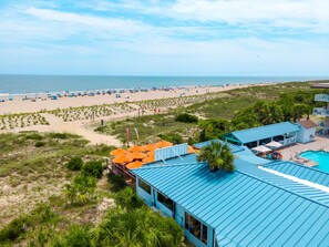 A beach resort with a swimming pool, beach umbrellas, and a view of the ocean. - Atlantic Ocean 8 | Stunning Views, Oceanfront, Two Pools (Tybee Island)