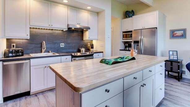 A modern kitchen with white cabinets, stainless steel appliances, and a wooden countertop. - Oceanfront getaway close to Gearhart Golf Links , no pets (Gearhart)