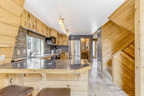 Eine moderne Küche mit Holzwänden, einer zentralen Kochinsel und Edelstahlgeräten.