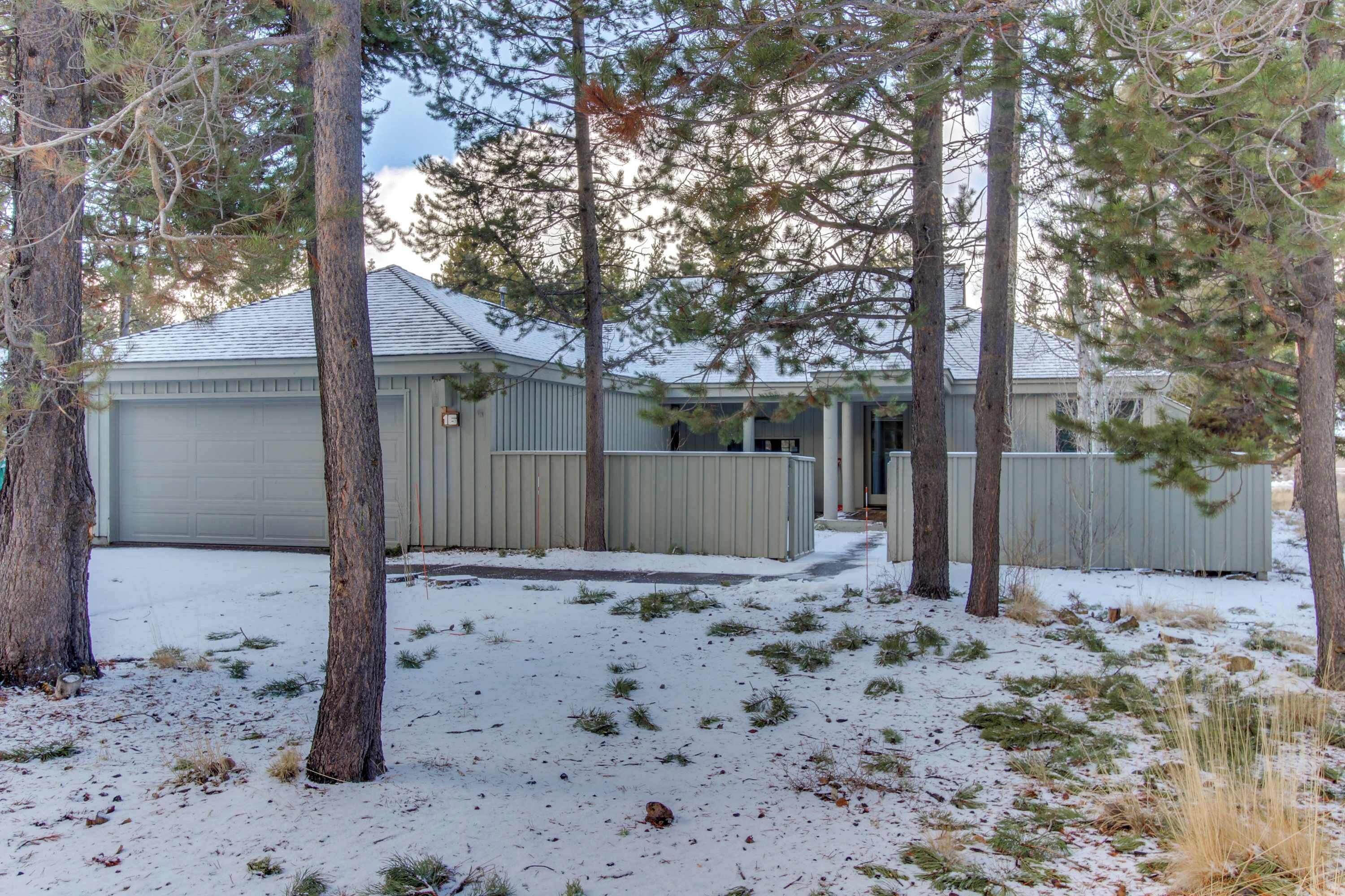 Una propiedad residencial con garaje, un espacio al aire libre cubierto y un patio cubierto de nieve.