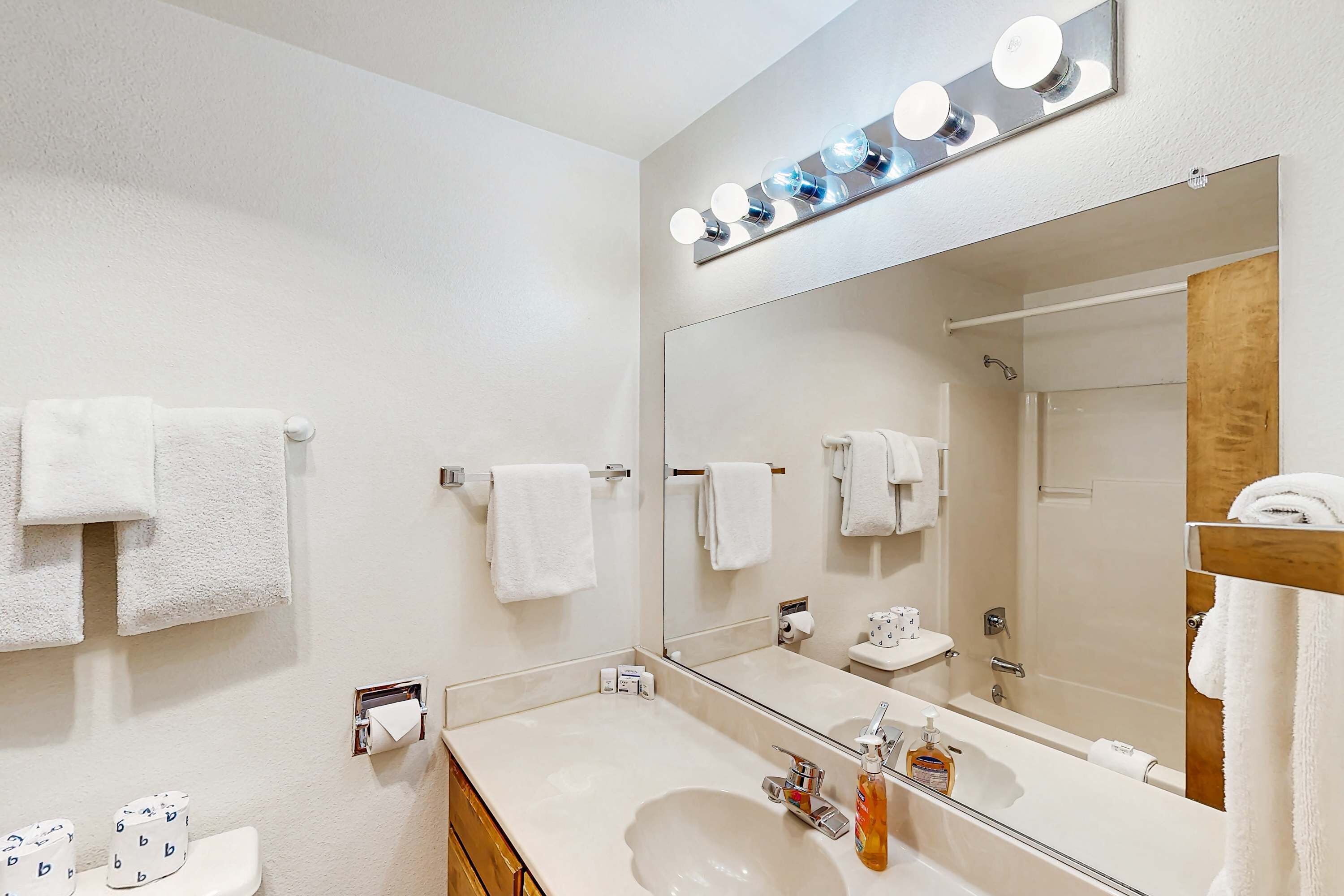 A bathroom with a sink, mirror, and towel rack.