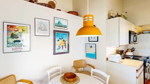 A compact kitchen with white cabinets, a stove, and a toaster.