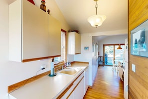 A modern kitchen with a large island, a built-in oven, and a dining area with a view.