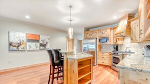 A kitchen with wooden cabinets, a stainless steel refrigerator, a microwave, and a built-in oven. - Lovely mountain condo with shared pool, hot tub, sauna & balcony views & free WiFi (Government Camp)