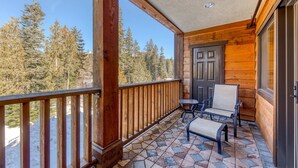 A wooden balcony with a tiled floor, a door, and two chairs. - Lovely mountain condo with shared pool, hot tub, sauna & balcony views & free WiFi (Government Camp)