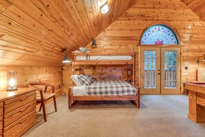 A wooden cabin bedroom with a bunk bed, a desk, and a chair. - Dog-Friendly, 3-Story Home & Loft with Deck, Private Hot Tub, Gas Grill, Pool Table (Government Camp)