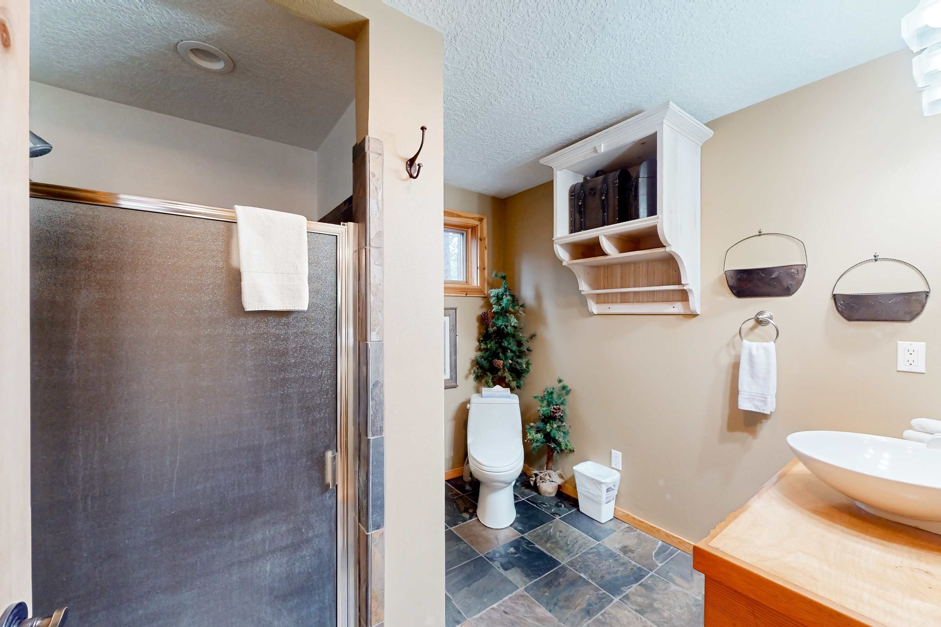 A bathroom with a shower, toilet, sink, and a small Christmas tree.