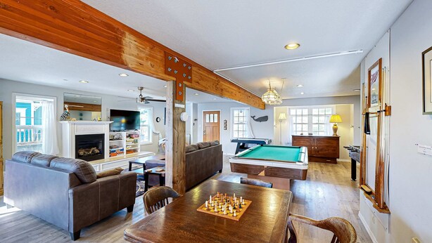 A spacious living area with a pool table, a fireplace, and a sofa. - Dog-friendly cottage with pool table, fast WiFi, fireplace, W/D - walk to beach (Long Beach)
