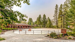 A paved courtyard with a picnic table, a covered seating area, and a signboard. - Mountain view condo with a fireplace, WiFi, partial AC, shared hot tub & pool (Bend)