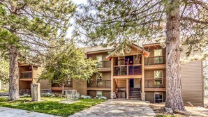 A multi-story building with balconies, a central staircase, and a paved walkway. - Mountain view condo with a fireplace, WiFi, partial AC, shared hot tub & pool (Bend)