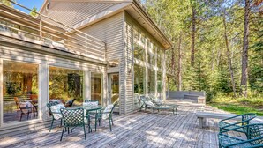 A modern house with a deck, large windows, and outdoor furniture. - Stylish & secluded home with a washer&dryer, fireplace, & resort amenity access (Black Butte Ranch)
