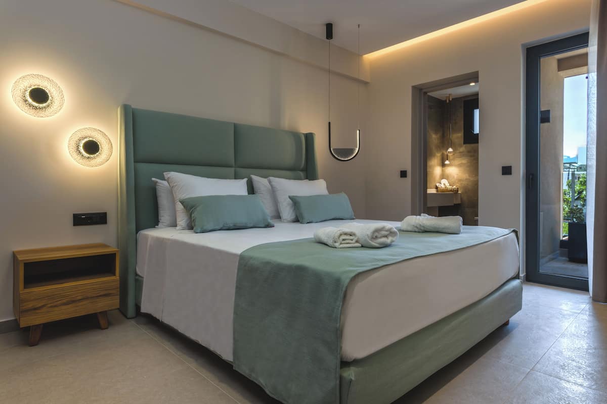 Un dormitorio moderno con una cama grande, mesitas de noche y vistas al exterior.