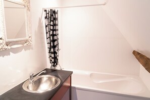 A bathroom with a sink, mirror, and bathtub. - House 4 at Domaine d'Embourg (Souvigny)