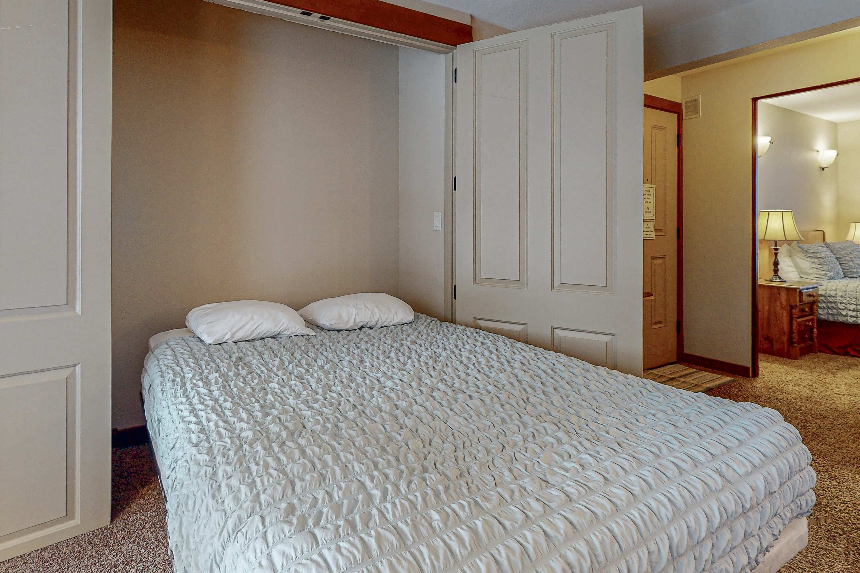 Een slaapkamer met een groot bed, een kledingkast en een spiegel.