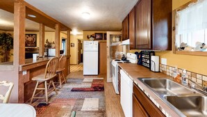 Una cucina con mobili in legno, un frigorifero, un fornello e un lavello.