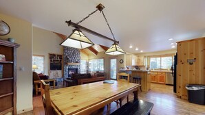 A spacious kitchen with wooden cabinets, a central island, and pendant lighting. - Sunriver home with WiFi, fireplace, private hot tub, & SHARC passes - dogs ok (Sunriver)