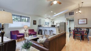 A spacious living area with a sofa, chairs, a dining table, and a kitchen in the background. - w/ private hot tub & easy access to downtown Bend (Bend)