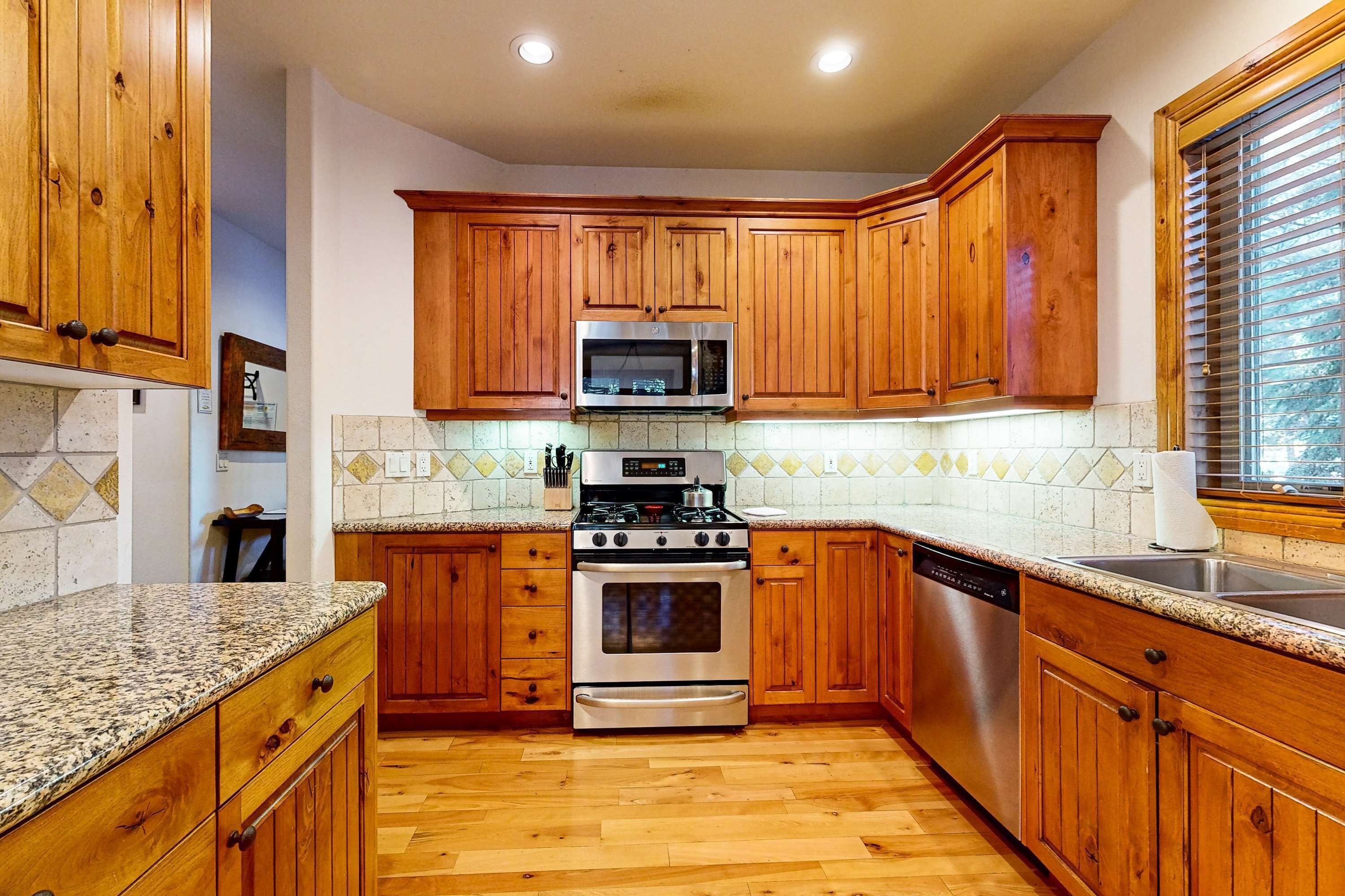 A kitchen with wooden cabinets, a stainless steel oven, a microwave, and a dishwasher.