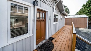 Une maison avec une terrasse en bois, une porte d’entrée et un garage.