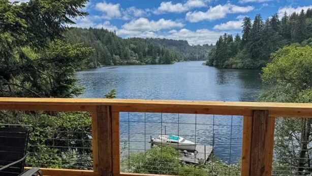 Un pontile di legno che si affaccia su un lago, con una barca ormeggiata nell'acqua.