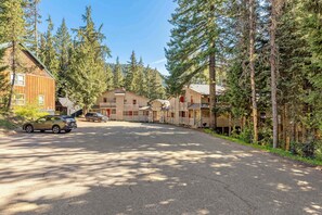 A lodge with multiple cabins, a parking area, and a forested backdrop. - Newly remodeled cabin-style condo near skiing & attractions - dogs welcome (Government Camp)
