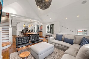 A spacious living area with a sofa, ottoman, and a dining table. - Creekside Haven- A Serene Creekside Escape from it All (Telluride)