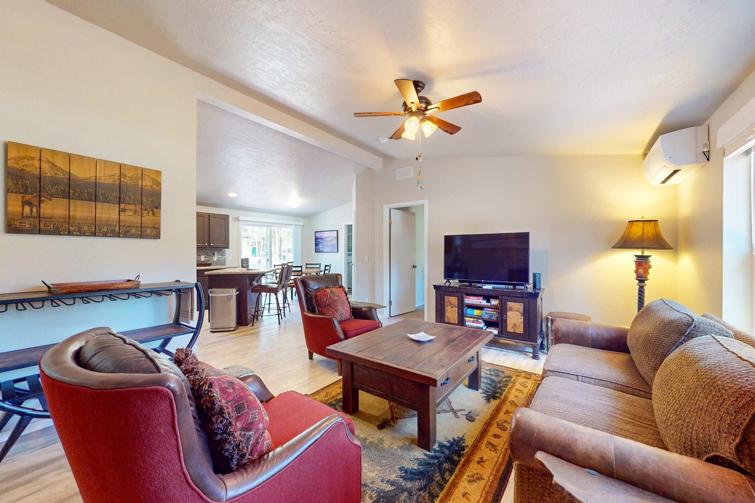 A living room with a ceiling fan, a television, a coffee table, and a sofa.
