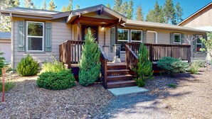 A single-story house with a front porch, a small staircase, and a well-maintained garden. - Cozy forest retreat near trails, slopes & Sunriver - perfect for year-round fun! (Bend)
